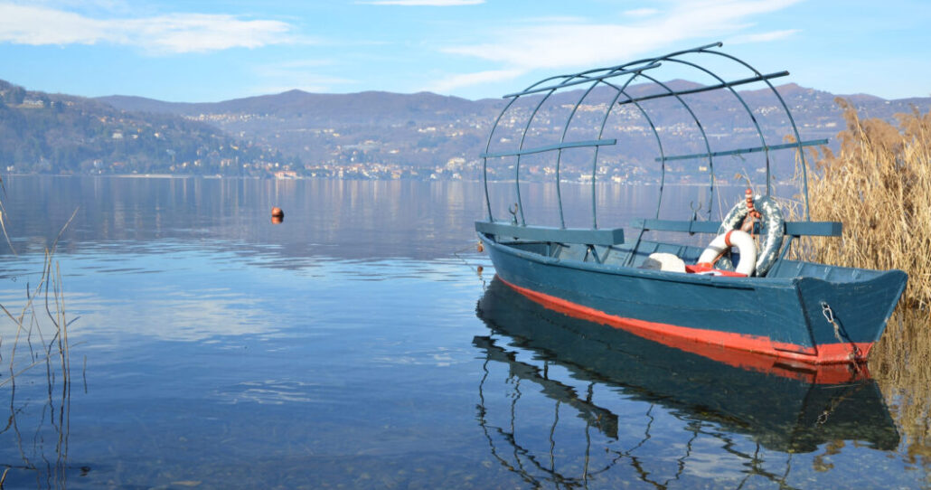 old-fishing-boat-lake-with-mountains old-fishing-boat-lake-with-mountains